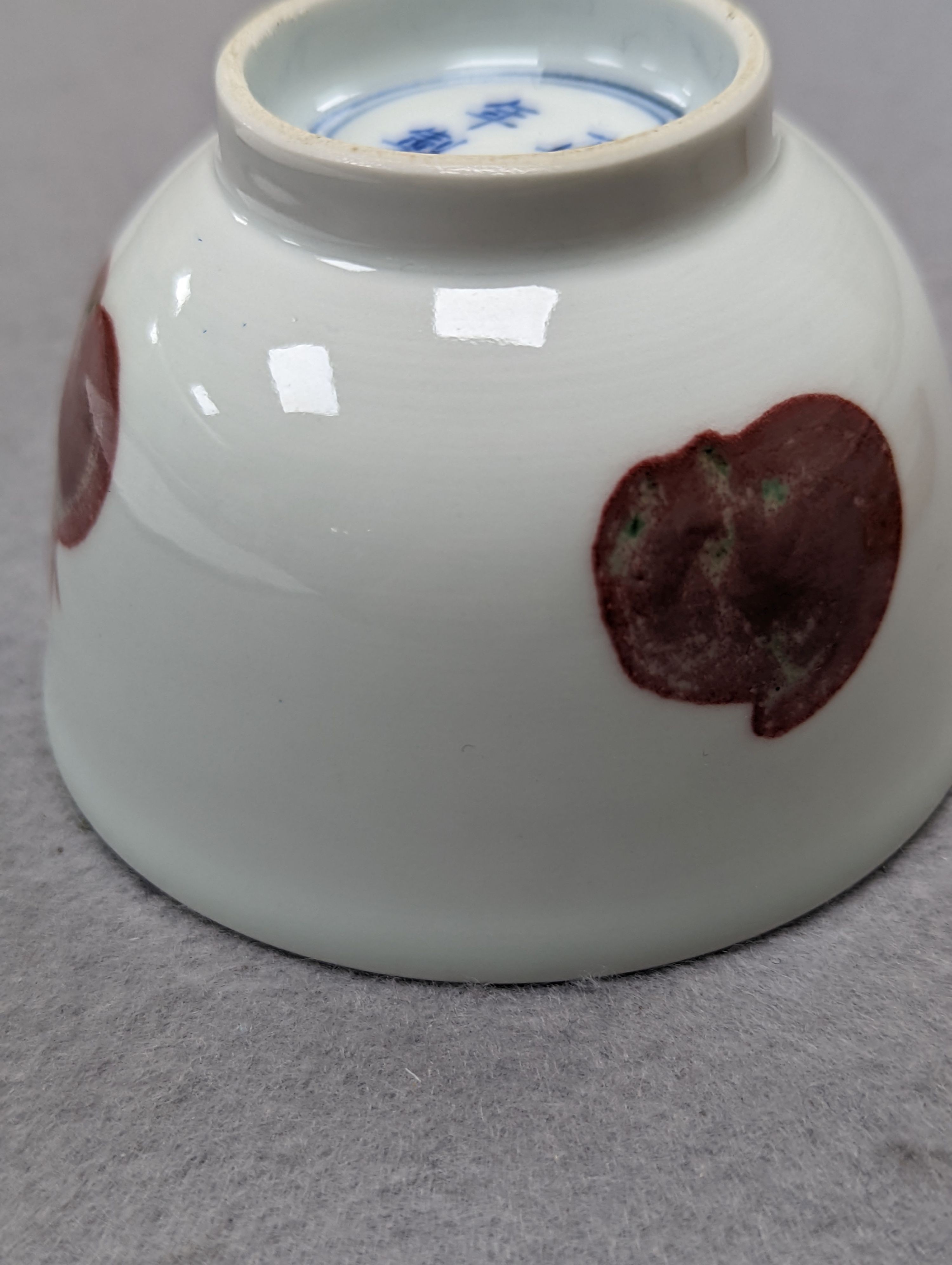 A Chinese porcelain teabowl with ‘fruit’ decoration, an agate bangle and a similar ‘basket’ carving.